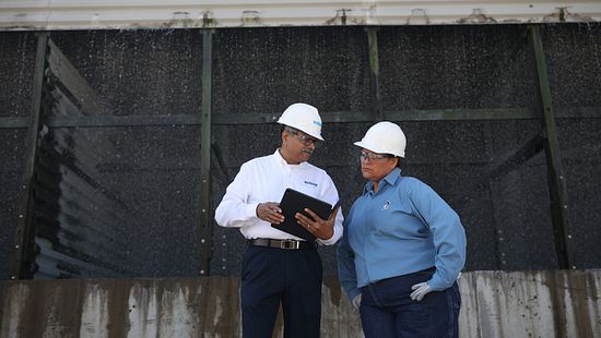 An Ecolab and ADM associate outside a cooling tower.